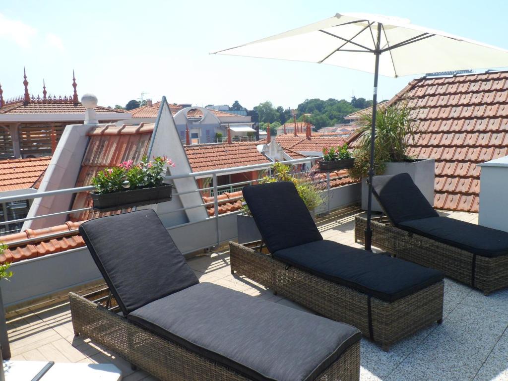 two chairs and an umbrella on a balcony at Residhome Arcachon Plazza in Arcachon