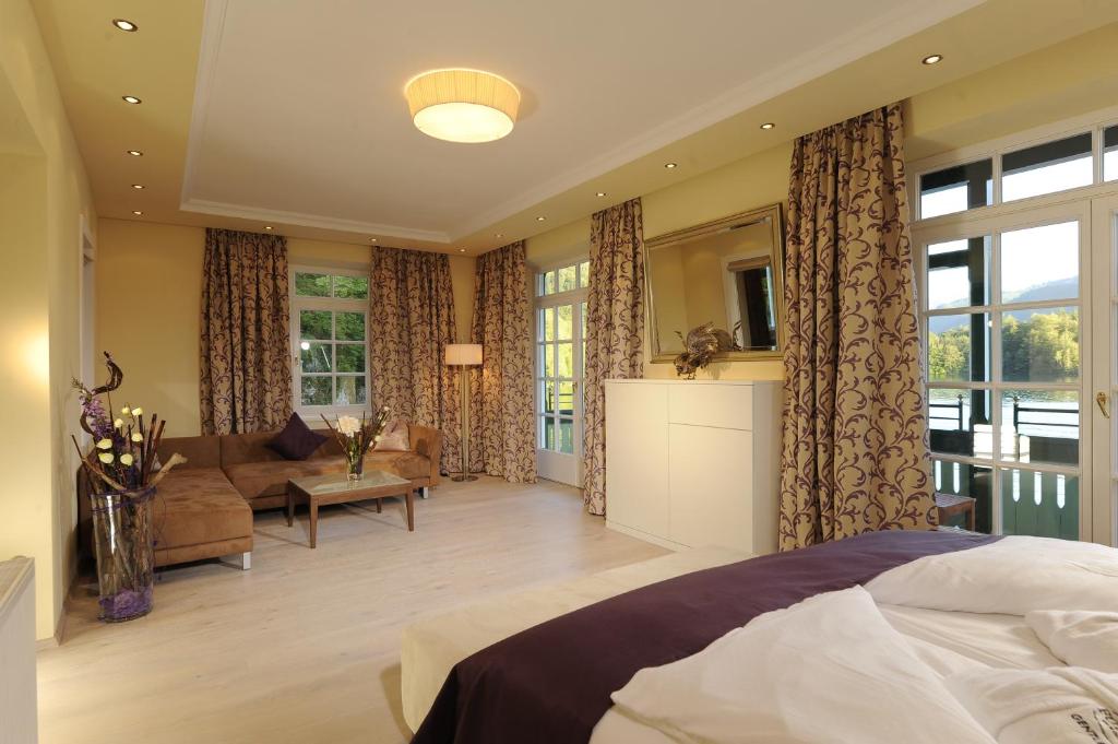 a bedroom with a bed and a living room at Hotel & Gasthof Fürberg in Sankt Gilgen