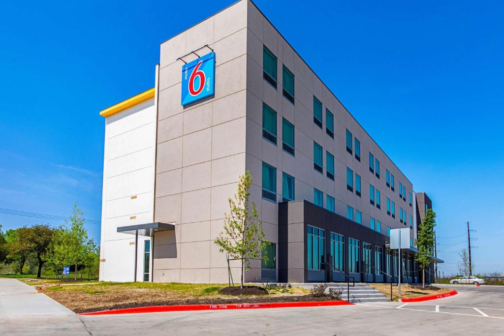 a building with a clock on the side of it at Motel 6 Austin Airport in Austin