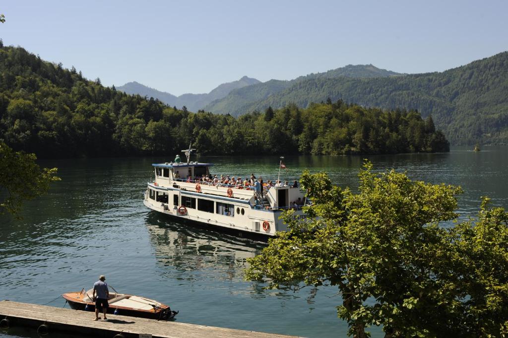 a boat on a river with a group of people on it at Hotel & Gasthof Fürberg in Sankt Gilgen
