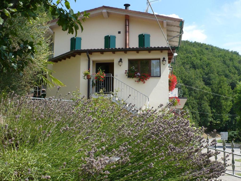 una casa en una colina con flores púrpuras en Solo Per Quattro, en Zocca