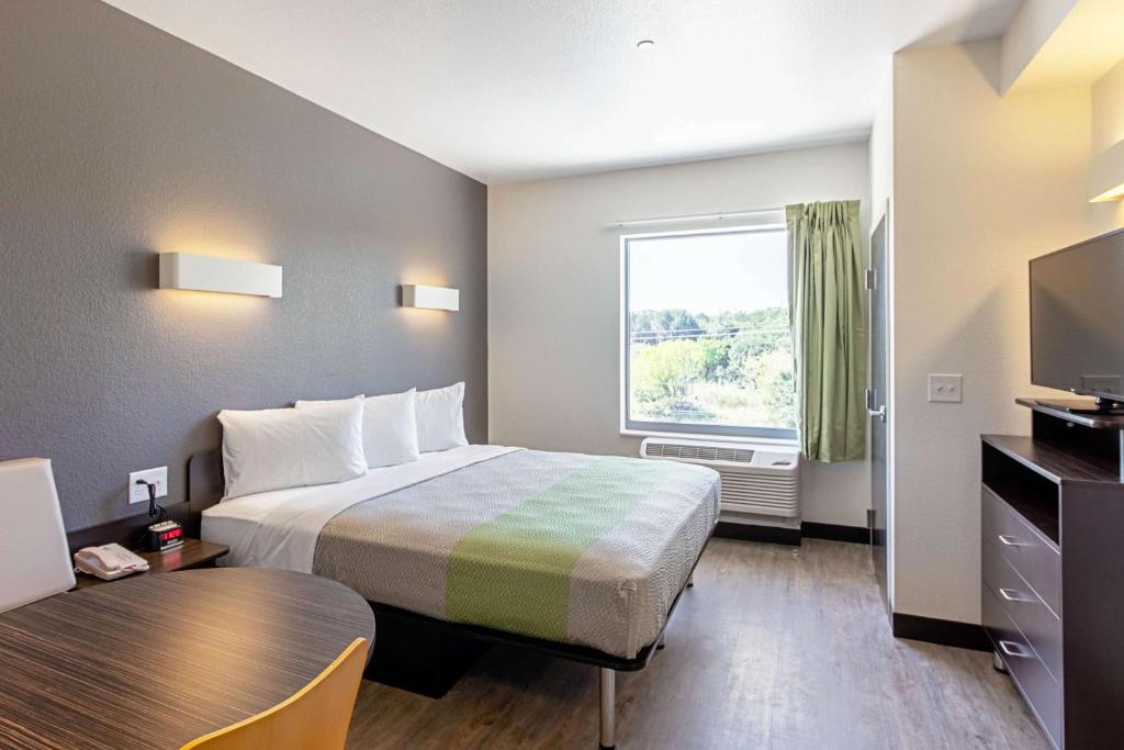 a hotel room with a bed and a window at Studio 6 Austin Airport in Austin