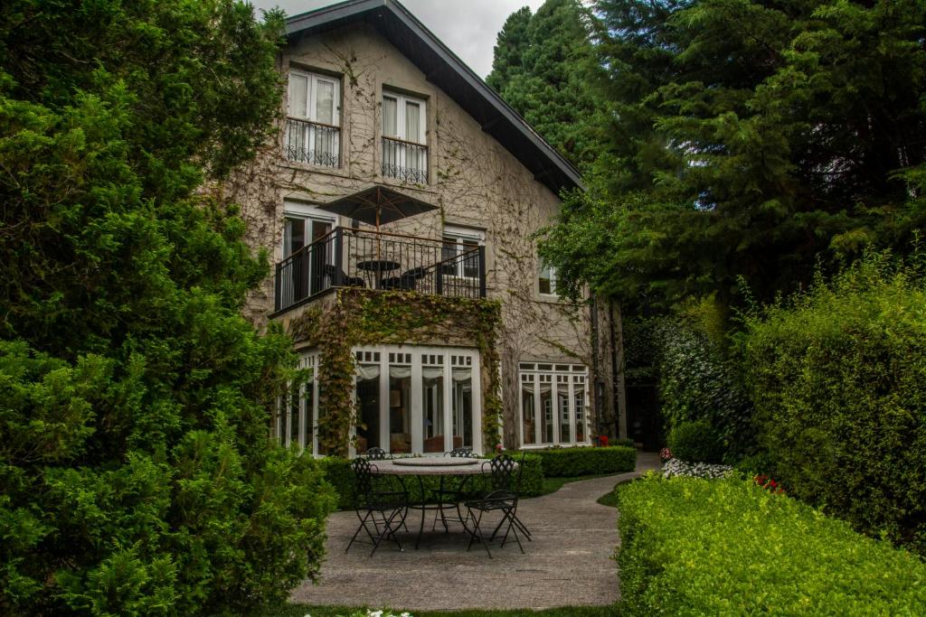 uma casa de pedra com uma mesa em frente em Casa Regaleira Hotel Boutique em Campos de Jordão