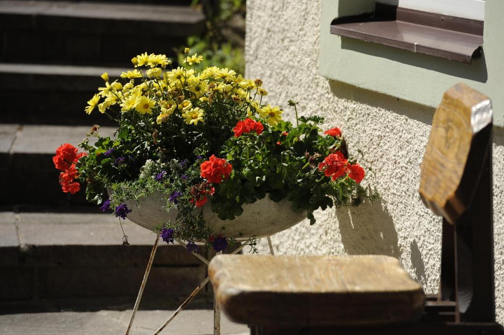 a pot of flowers on the side of a building at Hotel & Gasthof Fürberg in Sankt Gilgen