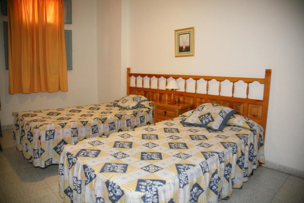 サン・セバスティアン・デ・ラ・ゴメラにあるApartamentos San Sebastiánのベッド2台と窓が備わる客室です。