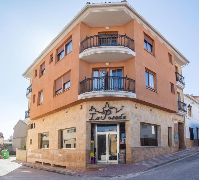 a tall orange building with a sign on it at LA POSADA DE HIGUERUELA in Higueruela