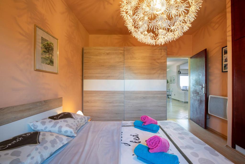 a bedroom with a large bed with a chandelier at Horizont view apartment in Pula