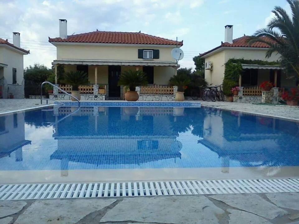 a swimming pool in front of a house at FOUFAS HOUSES in Paralion astros
