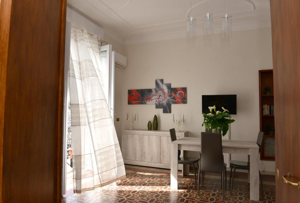 a dining room with a table and a table and chairs at Niria Home in Catania