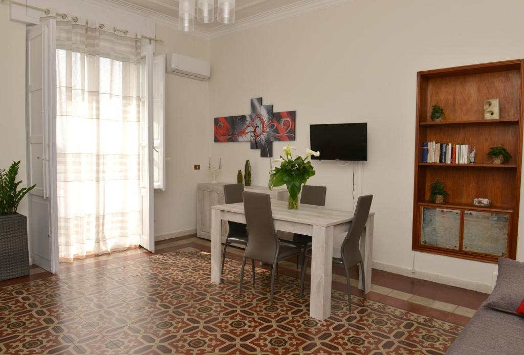 a dining room with a white table and chairs at Niria Home in Catania