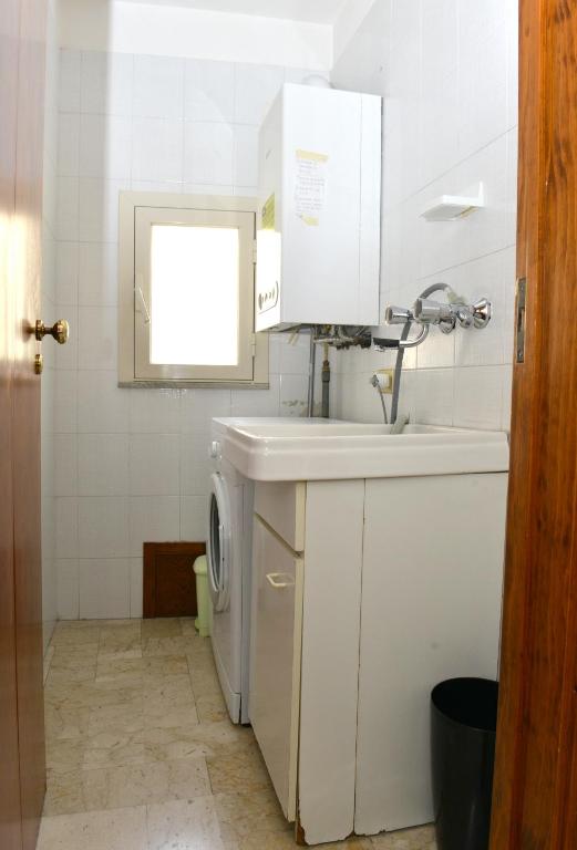 a bathroom with a sink and a washing machine at Niria Home in Catania