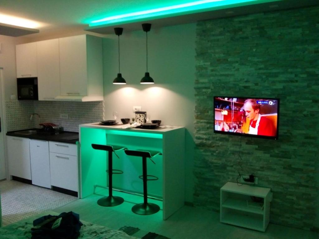 a kitchen with a green island with a tv on the wall at Victoria in Vračar (historical)