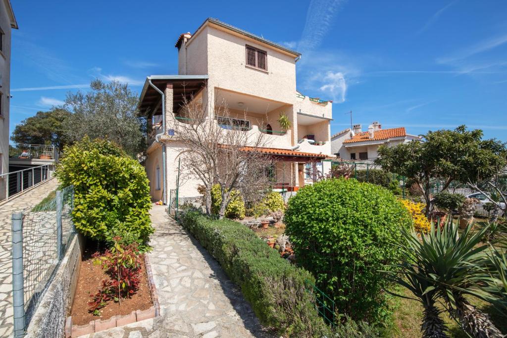 a house with bushes and a walkway in front of it at Horizont view apartment in Pula