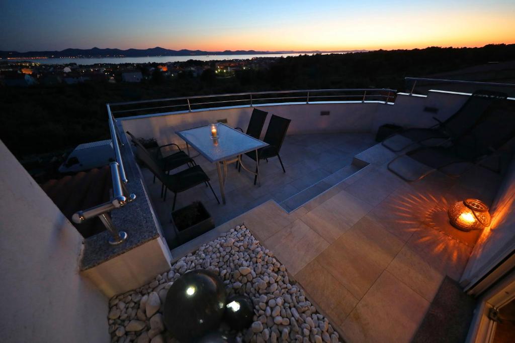 Elle offre une vue sur la terrasse dotée d'une table et de chaises. dans l'établissement Magic Blue Sky Apartment, à Zadar