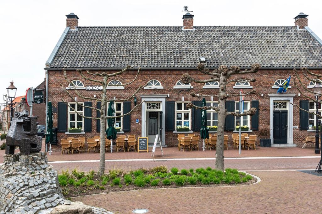 a brick building with tables and chairs in front of it at Mert 5 in Beesel