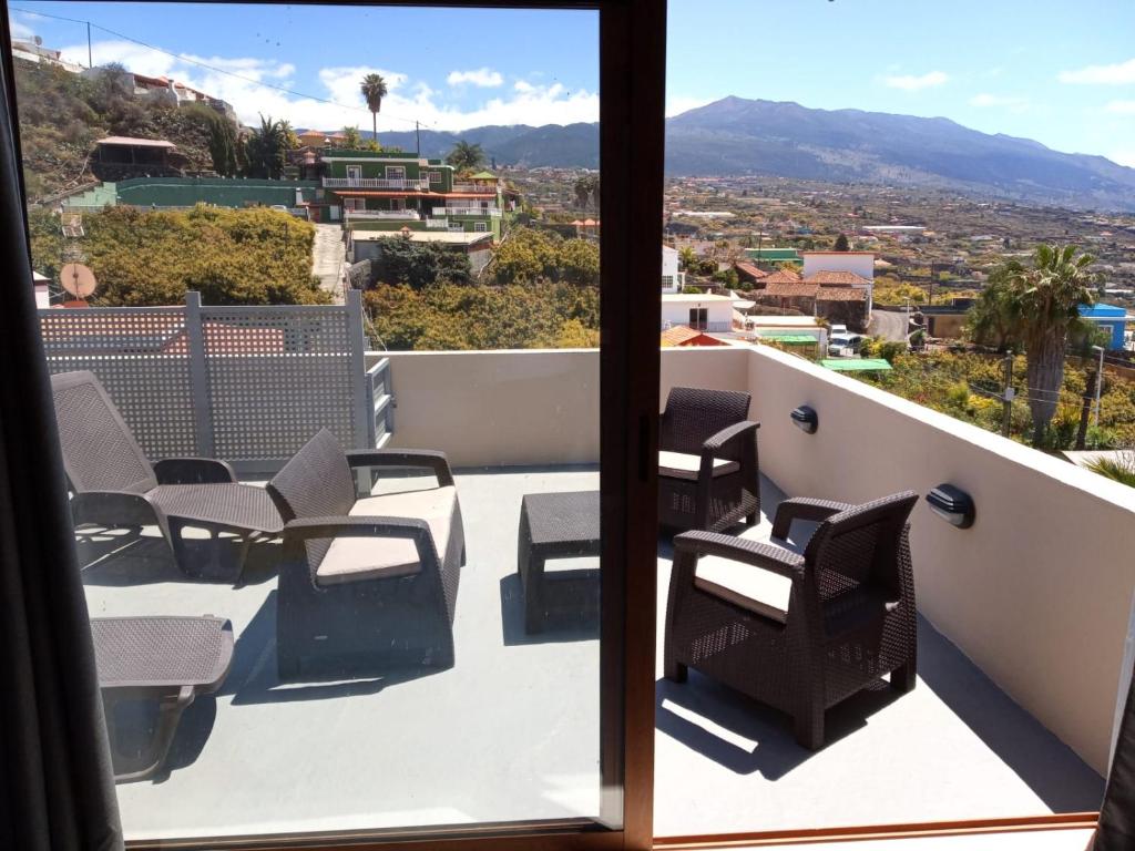 a balcony with chairs and a view of a city at Ático Los Lomos in El Paso