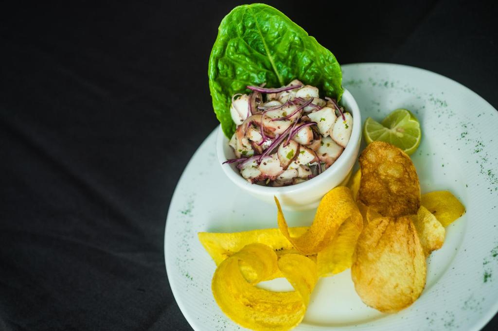 a plate of food with a salad and onion rings at Riande Aeropuerto Hotel Casino in Tocumen