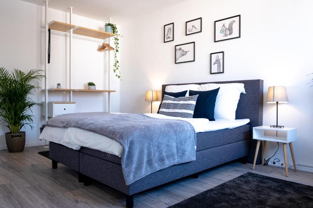 1 dormitorio con 1 cama con colcha azul y blanca en Helles Design-Appartement an der Messe, en Essen
