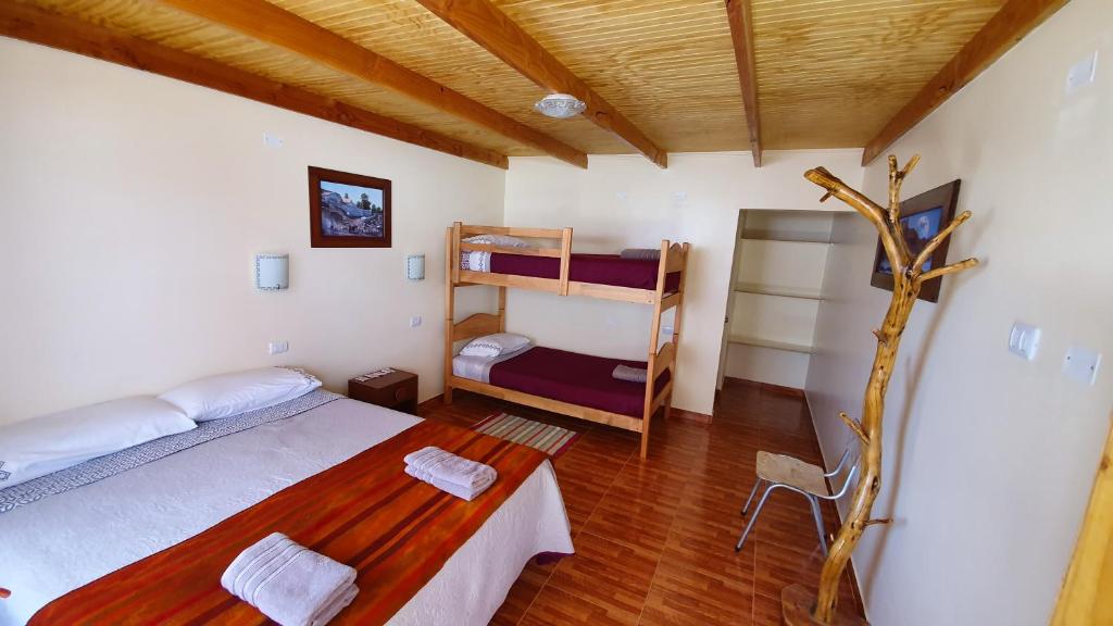 a bedroom with two bunk beds and a table at Hostal Ckamai in San Pedro de Atacama