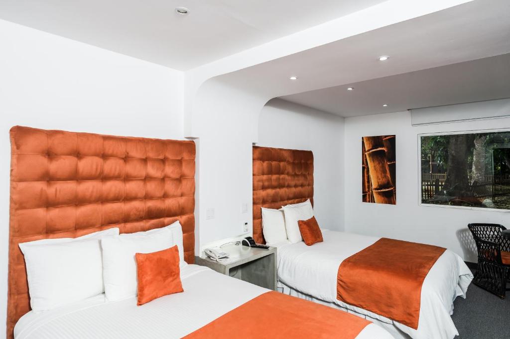 a hotel room with two beds and a large headboard at Riande Aeropuerto Hotel Casino in Tocumen
