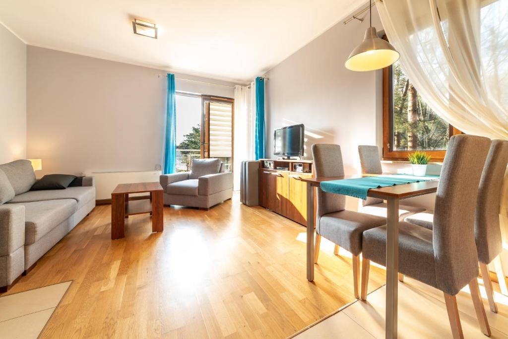 a living room with a couch and a table at Villa 4 Pory Roku in Jastrzębia Góra