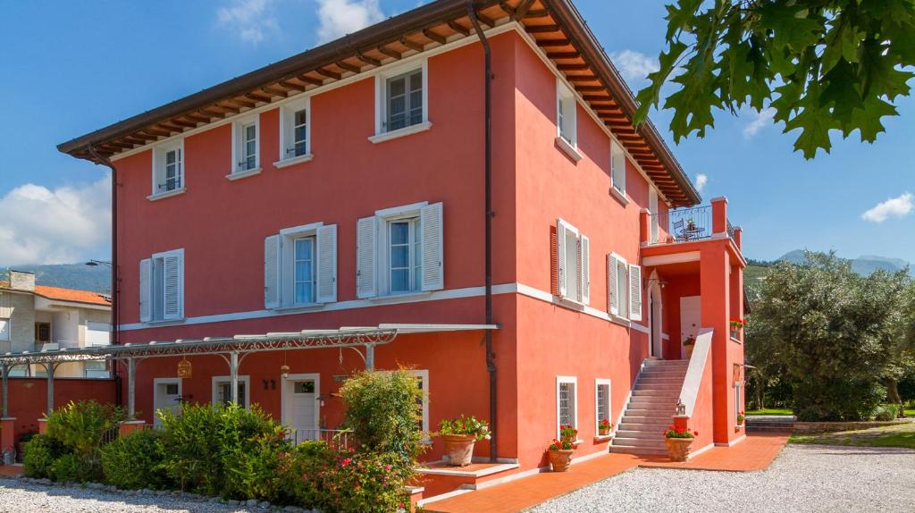 ein rotes Haus mit weißen Fenstern und einer Treppe in der Unterkunft Suite Agave in Seravezza