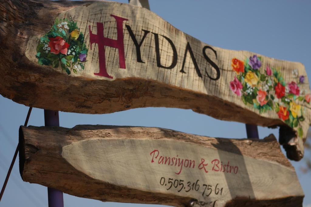 a sign that says miracles with flowers on it at Hydas Pension in Selimiye