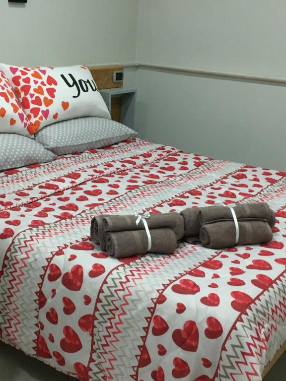 un letto con un piumone rosso e bianco sopra di Casa vacanza dei Greci a Barletta