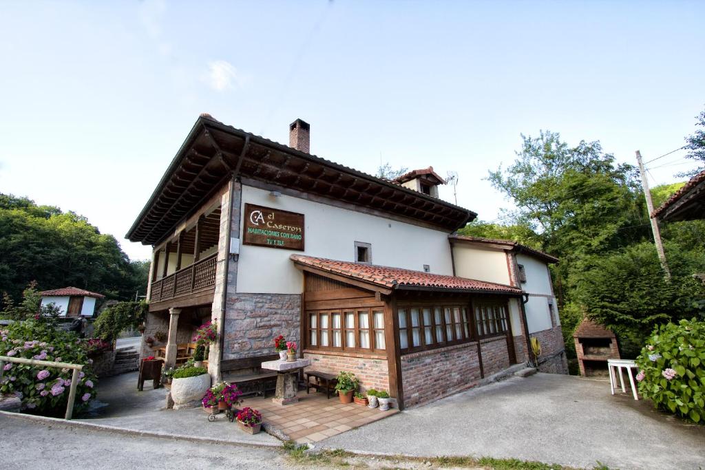 a small white building with a table in front of it at Hotel Rural El Caserón in Soto de Cangas