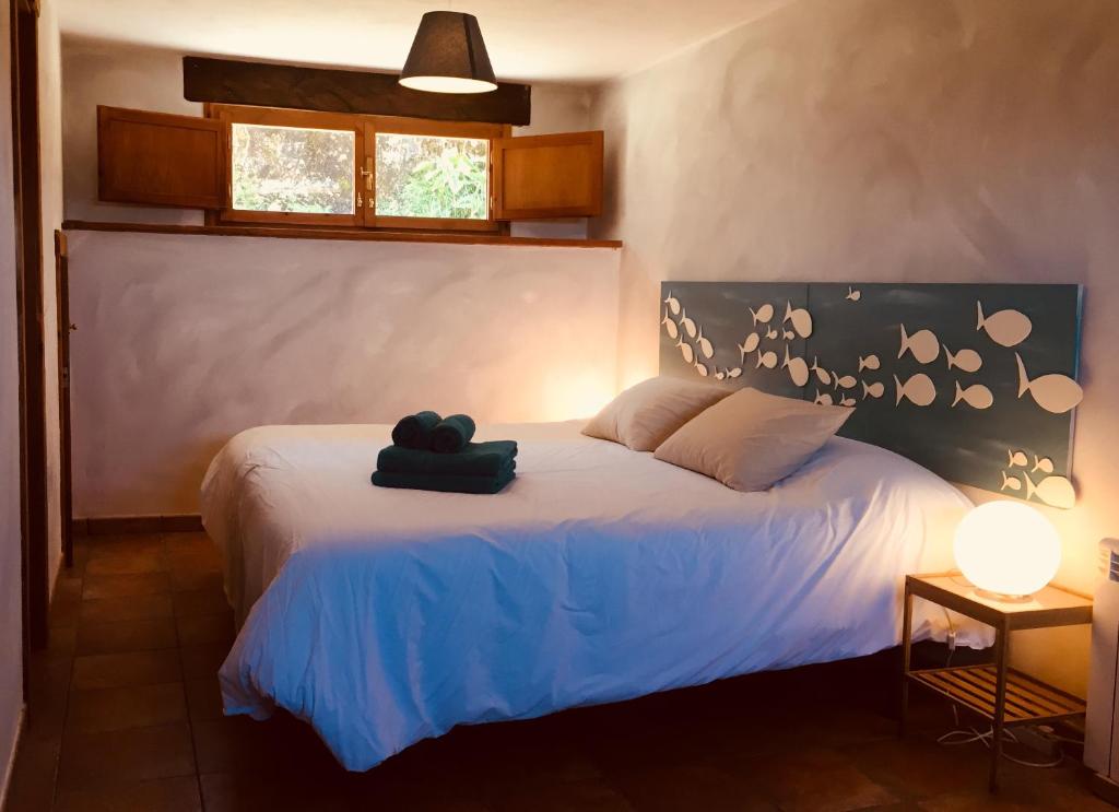 a bedroom with a white bed with a black headboard at Casa Azul Rodiles in Selorio