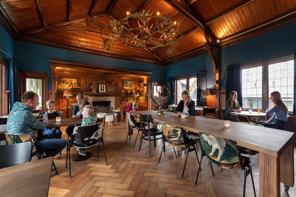 un groupe de personnes assises à table dans un restaurant dans l'établissement Stayokay Hostel Gorssel - Deventer, à Gorssel