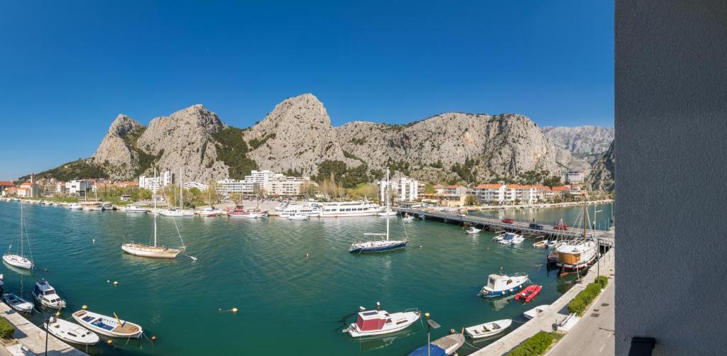 eine Gruppe von Booten, die in einem Hafen mit Bergen angedockt sind in der Unterkunft Mary in Omiš