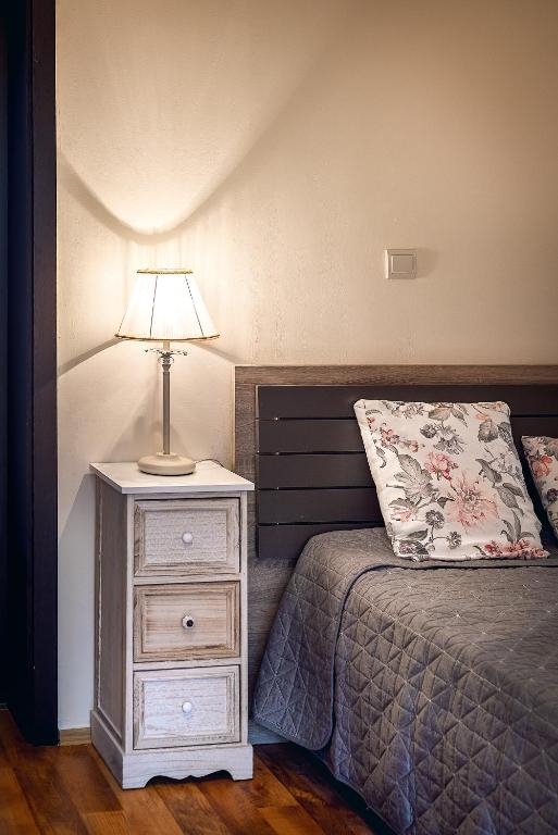 a bedroom with a bed and a nightstand with a lamp at Villa Milana Budva in Budva