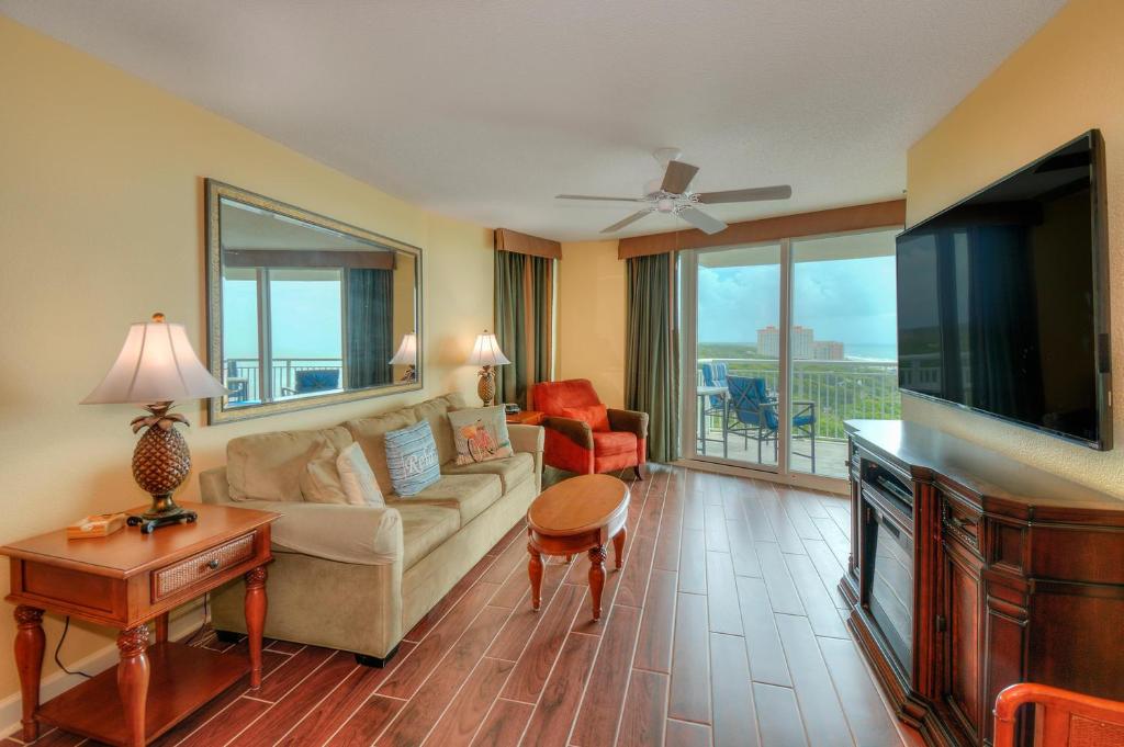 uma sala de estar com um sofá e uma televisão em Horizon at 77th Avenue North by Palmetto Vacations em Myrtle Beach