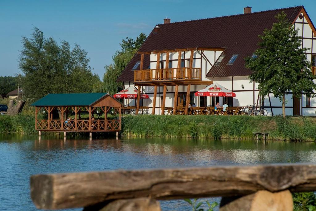 un gran edificio junto a una masa de agua en Restauracja Teo, en Cieszków