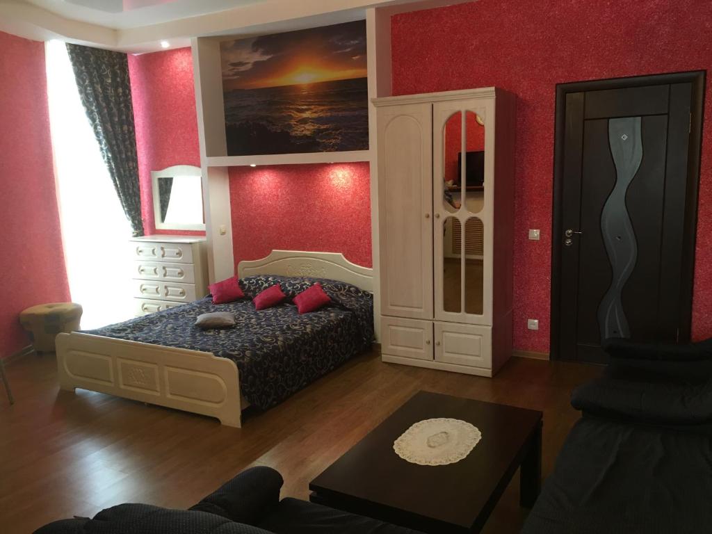 1 dormitorio con 1 cama y paredes rojas en Severniy Hotel, en Ujtá