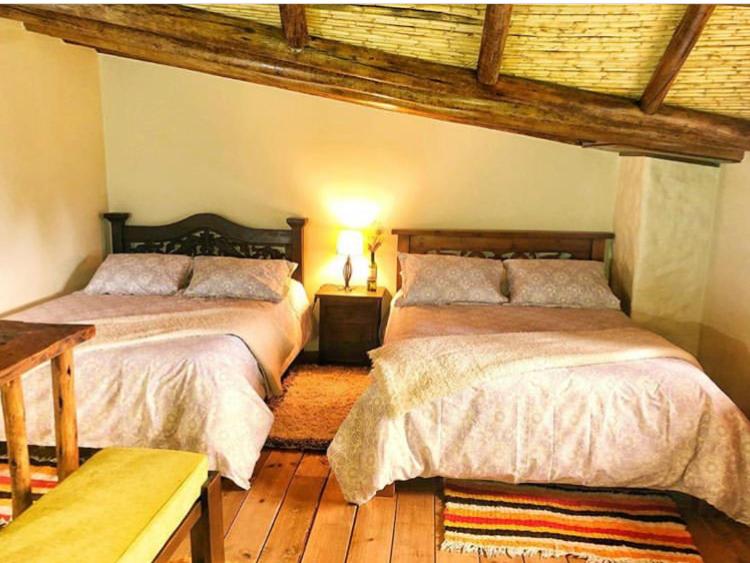 a bedroom with two beds and a wooden floor at Cabaña Campestre San Fernando in Iza