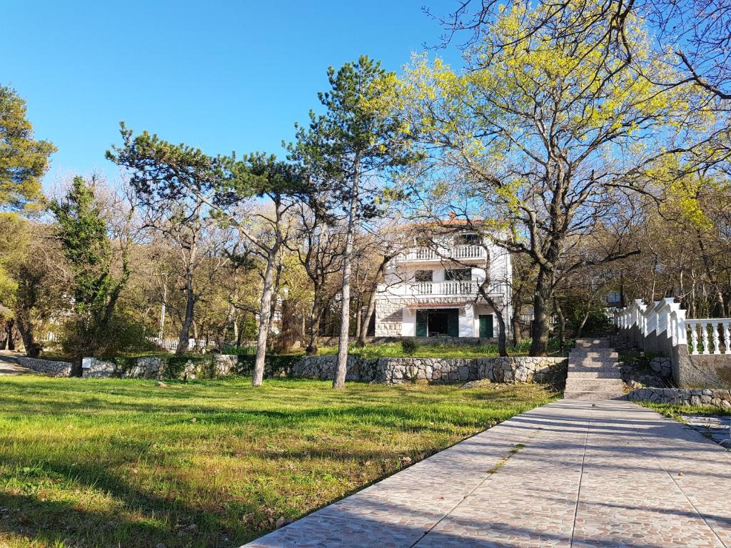 a house in the middle of a park with a sidewalk at Vila Kajče in Omišalj