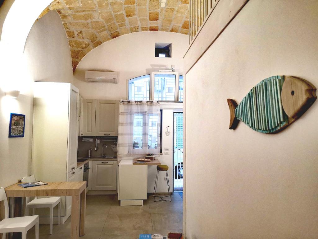 een keuken en eetkamer met een vis aan de muur bij Dimora Del Mar in Polignano a Mare