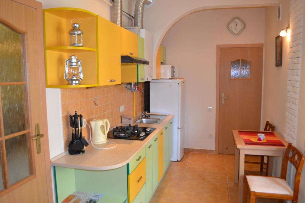 una cocina con armarios amarillos y verdes y fregadero en Near Citadel Apartment, en Leópolis