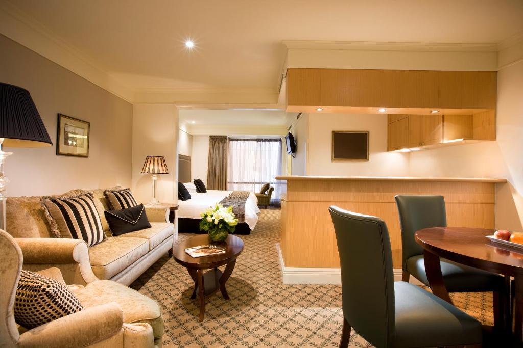 a living room with a couch and a table at Stamford Plaza Melbourne in Melbourne