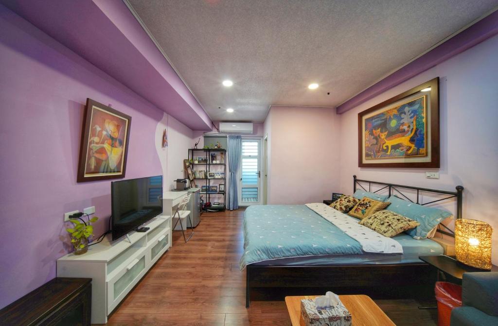 a bedroom with purple walls and a bed and a tv at Happy宅 in Tainan