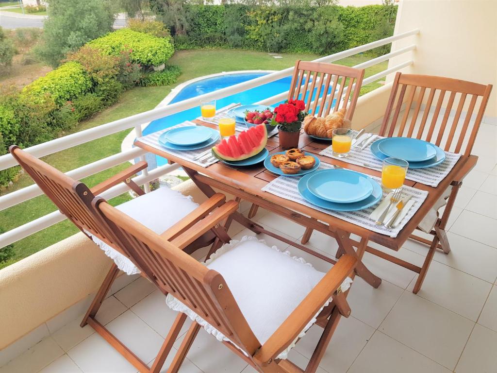 a table with food and fruit on a balcony at Ocean Cascais - Apartment with Swimming Pool in Cascais