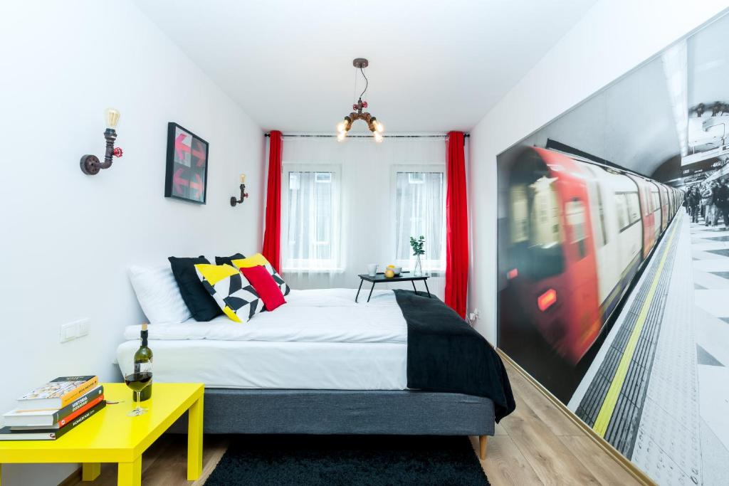 um quarto com uma cama e uma mesa amarela em Sleepway Apartments - Red Metro em Poznań