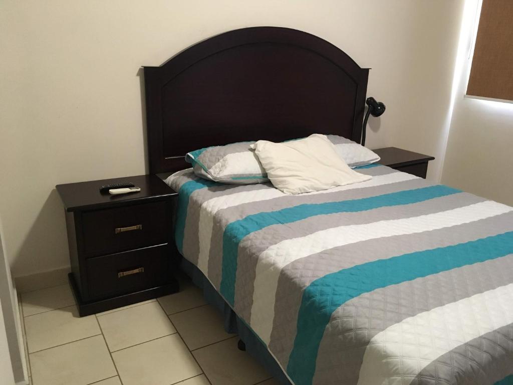 um quarto com uma cama com uma cabeceira preta e uma mesa de cabeceira em Apartamento Climatizado, 2 Habitaciones y Piscina em Tegucigalpa