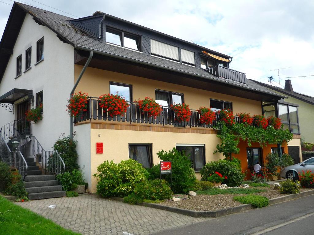 una casa con flores rojas en el balcón en Ferienhaus Stülb, en Zeltingen-Rachtig