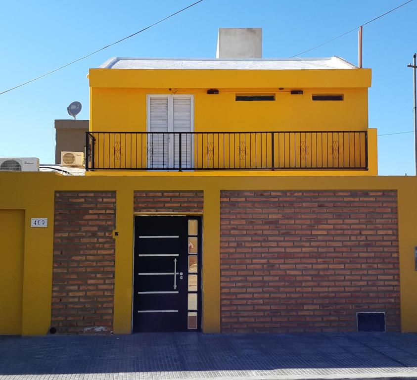 a yellow building with a door and a balcony at CasaGrande Hotel in Chilecito