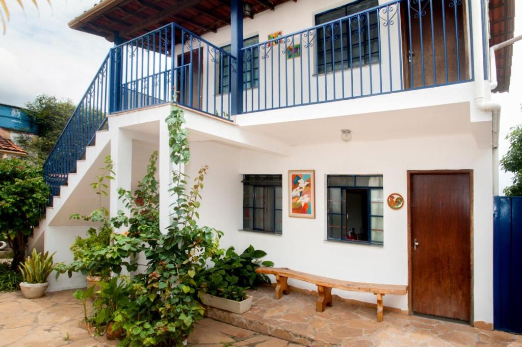 a house with a bench in front of it at Pousada Casa da Cintia in Diamantina