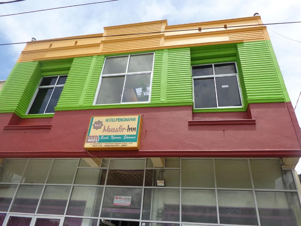 a colorful building with green and red trim at Hotel Musafir Inn in Padang