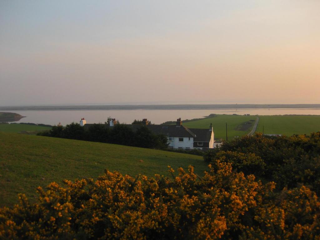 a house on a hill with the ocean in the background at Moonfleet in Chickerell